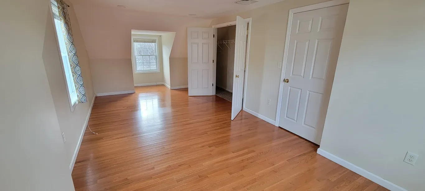 Clean empty bedroom with wood floors